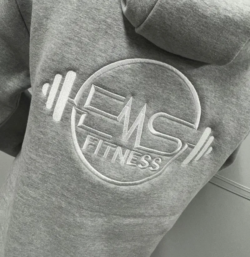 Large embroidered EMS Fitness logo on the back of a hoodie